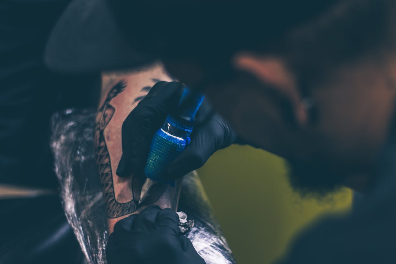 Close-up of a tattoo artist creating art on a client's arm.